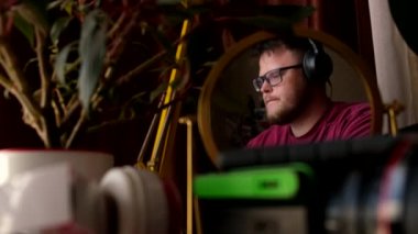 Kulaklık takmış bir adamın yansıması. Laptop kopyalama alanı üzerinde çalışan müzik dinliyor.