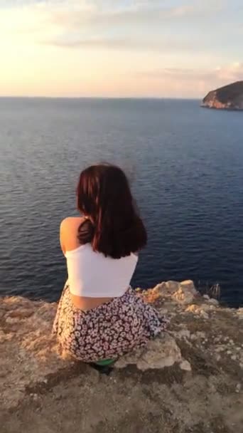 Kvinna Sitter Klippan Njuter Solnedgången Ovanför Havet Sommarsemester — Stockvideo