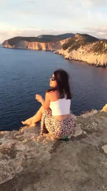 Mulher Sentada Penhasco Desfrutando Pôr Sol Acima Mar Férias Verão — Vídeo de Stock