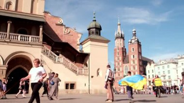 Krakow, Polonya - 19 Mayıs 2022: Polonya eski şehir meydanında Ukrayna bayrağıyla koşan küçük çocuk. sığınak