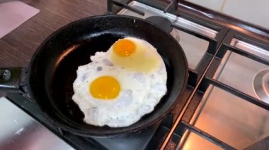 frying eggs on the pan overhead view super slow motion home kitchen