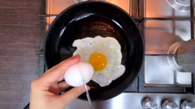 frying eggs on the pan overhead view super slow motion home kitchen