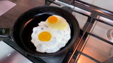 frying eggs on the pan overhead view super slow motion home kitchen