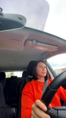 Turuncu kazaklı kadın araba selfie 'si kullanıyor.