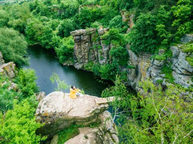 Kadın tepede oturuyor Kanyon nehri ormanının manzarasının tadını çıkarıyor