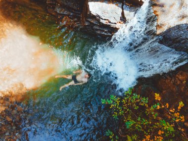 Sonbahar şelalesinde yüzen insan manzarası