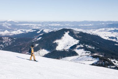 Yamacın tepesinde snowboard yapan bir adam var. Güzel kış dağları. Kış tatili kopyalama alanı. ekstrem spor