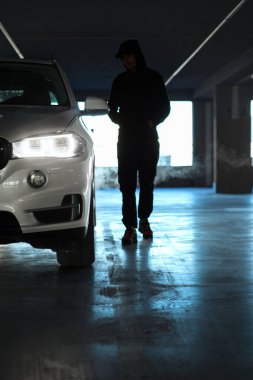 Park yerinin altındaki otoparka doğru yürüyen bir adam.