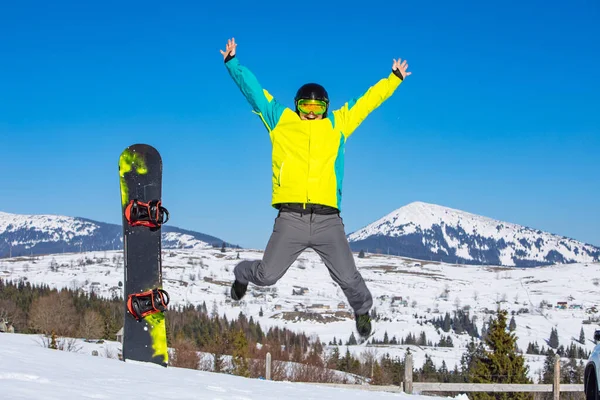Snowboard Sopasının Yakınından Atlayan Adam Arka Plandaki Kar Dağlarında Güneşli — Stok fotoğraf
