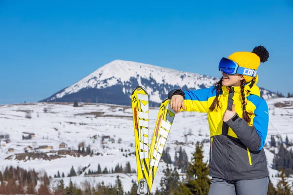 Joven Sonriente Bonita Mujer Sosteniendo Esquí Montañas Fondo Viajes Invierno —  Fotos de Stock