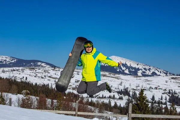 Άνθρωπος Άλμα Snowboard Στα Χέρια Βουνά Στο Παρασκήνιο Ηλιόλουστη Μέρα — Φωτογραφία Αρχείου