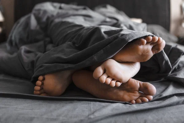 Paar Füße Unter Der Decke Bett Mit Grauen Laken Nahaufnahme — Stockfoto