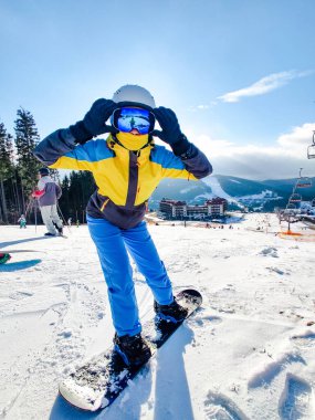 Kar tepesinde poz veren bir kadın.