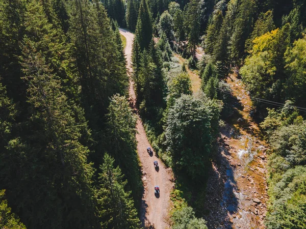 Dağ yolu kopyalama alanındaki dörtlü bisiklet sürücülerinin hava görüntüsü