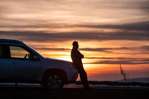 Άνθρωπος Στέκεται Κοντά Στο Αυτοκίνητο Στο Ηλιοβασίλεμα Έννοια Αυτοκίνητο Ταξίδια — Φωτογραφία Αρχείου