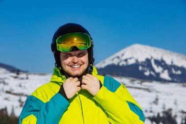 Miğferli ve kar maskeli adam. Yansıma. Kış aktivitesi. güneşli bir gün
