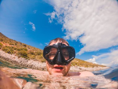 Şnorkel maskeli adam yaz tatilinde selfie çekiyor.