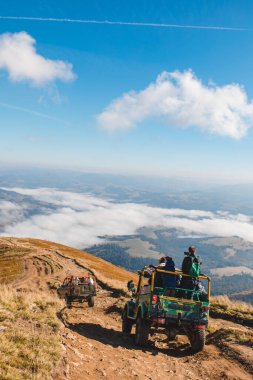 Dağ zirvesinde arazi araçlarına binen insanlar fotokopi alanı