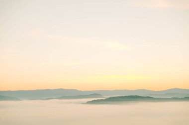 Dağların tepesindeki güneşin doğuşunun manzarası.