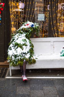 Noel ağacı, kadın bacaklarıyla ahşap bankta tatil zamanı oturuyor.