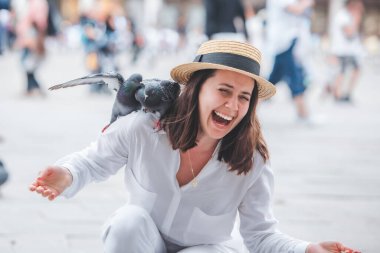 Beyaz şapkalı kadın Venice City Meydanı San Marco 'da güvercinlerle eğleniyor.