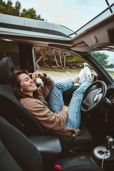 車の中で休んでる女性が海のビーチに停まって 夏休み — ストック写真