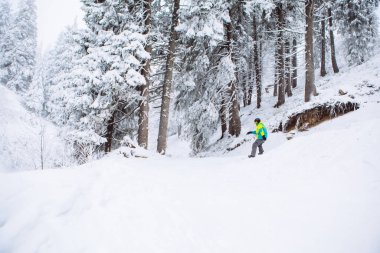Kış ormanlarında snowboardçu adam Boşluğu kopyaladı