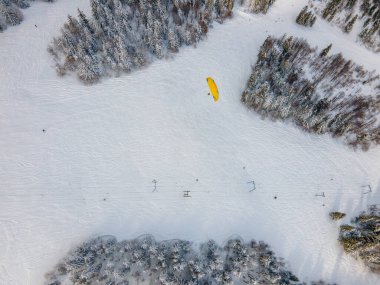 Dağdaki kayak pistinin üstündeki kayak paraşütçüsü.