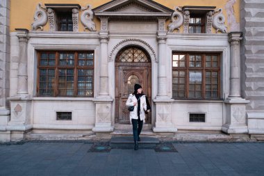 Kış kıyafetli modern bir kadın sokakta yürüyor.