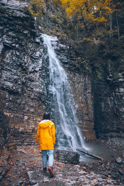 Frau Gelbem Regenmantel Beim Herbstwasserfall Wanderkonzept — Stockfoto