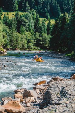 Dağlar, yaz mevsiminde rafting yapıyor. Boşluğu kopyala