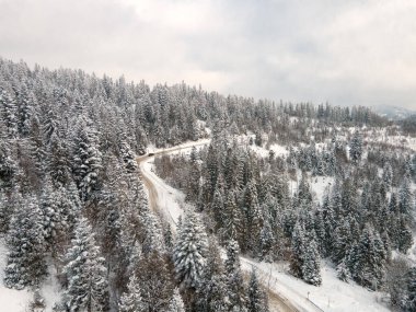 Karpatya dağlarının kış mevsiminde karlı yolun havadan görünüşü
