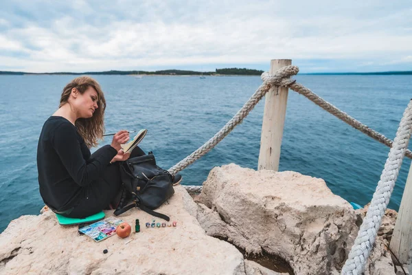 Kenarda Oturan Kadın Deniz Manzaralı Asma Köprü Resmi Çiziyor — Stok fotoğraf