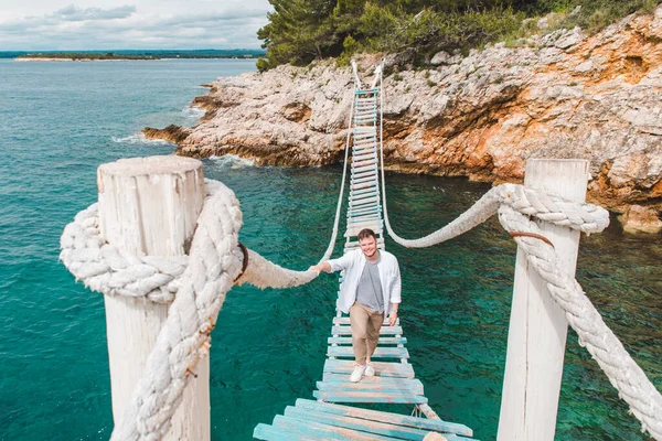 Man walking by suspension bridge — Stock Photo, Image
