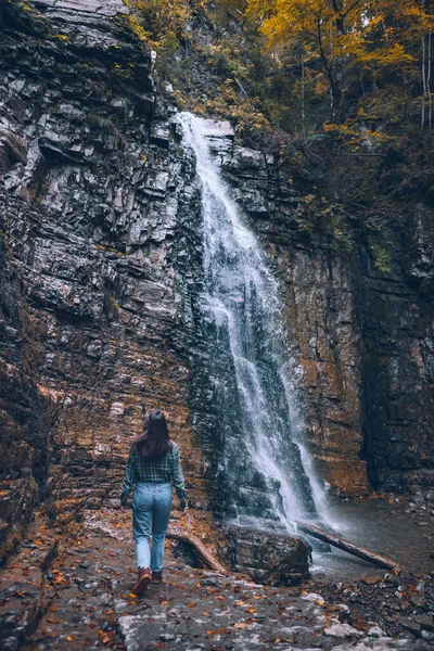 Şelale fotokopi alanına bakan günlük elbiseli bir kadın.