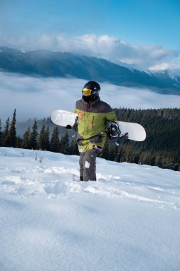 Snowboard sporcusu, arka plandaki Carpathian dağlarının portresi.