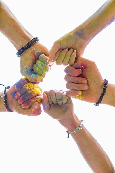 Друзья закрывают руки в краске Холи. копировальное пространство