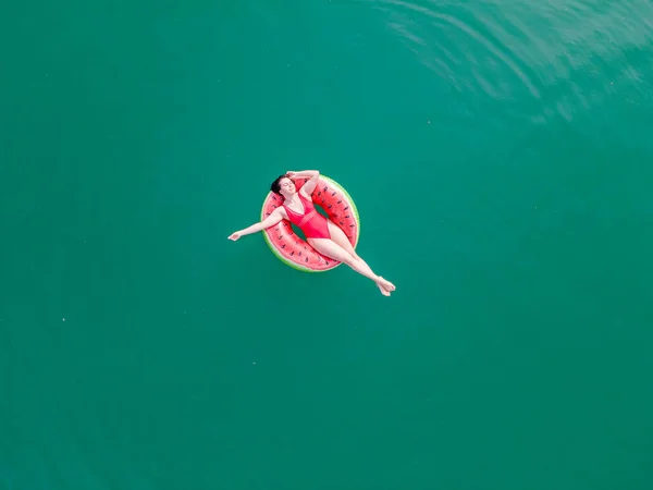 Fiatal boldog nő úszó kék azúrkék víz felfújható gyűrű kör — Stock Fotó