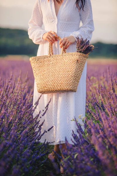 Woman in white dress holding bouquet of lavender flowers — Stock Photo, Image