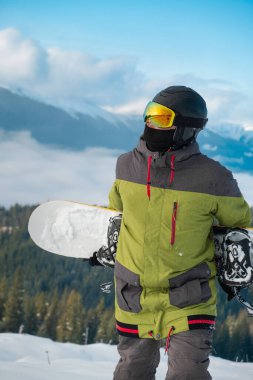 Snowboard sporcusu, arka plandaki Carpathian dağlarının portresi.