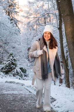 Kış parkında yürüyen gülümseyen kadın fotokopi alanı