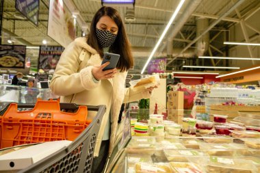 Mağazadaki kadın market alışverişini seçiyor.