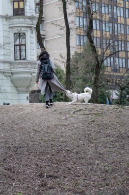 Lviv, Ukrayna - 3 Nisan 2021: Kopya alanını ısırmak için köpeği biten kadın