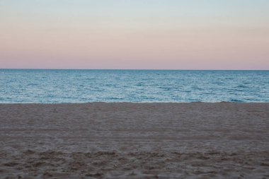 Kumlu deniz sahilinde alacakaranlık manzarası. Boşluğu kopyala