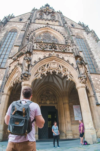 背着背包的游客看着古老的哥特式教堂的仿制空间 — 图库照片