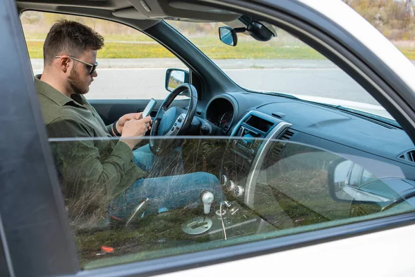 Mężczyzna Siedzi Samochodzie Pomocą Telefonu Rozproszony Styl Życia — Zdjęcie stockowe