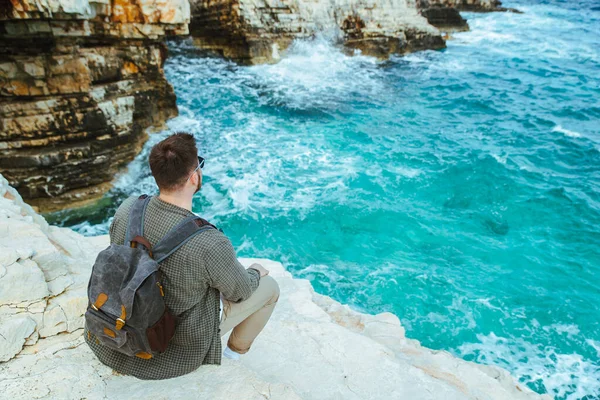 Homem Com Mochila Sentado Penhasco Desfrutando Vista Para Cidade Férias — Fotografia de Stock