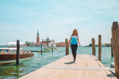 Turist kadın San Giorgio Maggiore Venedik 'e bakıyor.