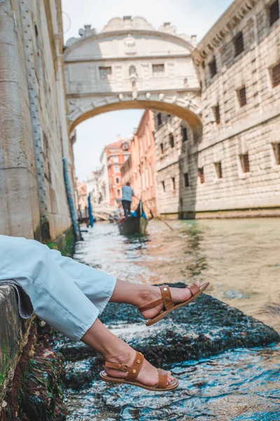 Kvinna som sitter vid City Quay i Venedig Italien njuter av utsikten över kanalerna med gondoler — Stockfoto