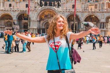 İtalya, Venedik - 25 Mayıs 2019: Saint Marks Meydanı 'ndaki turist kadın ve güvercinler yaz tatili